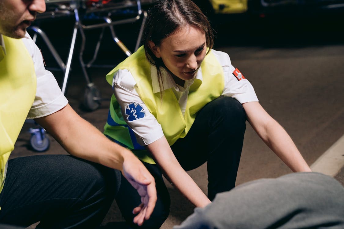 Paramedics providing emergency care to a casualty at an accident scene, representing the first responder expertise behind Accident Support