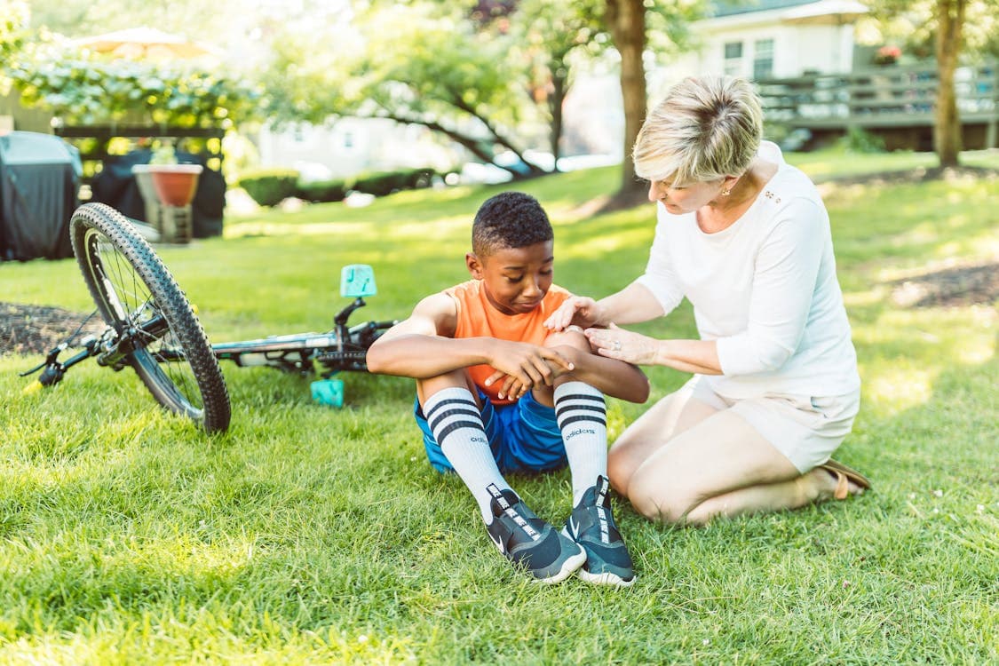 Bicycle rider examining an injury after an accident, representing the vulnerability of cyclists in traffic